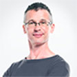 A man with glasses is smiling for the camera.