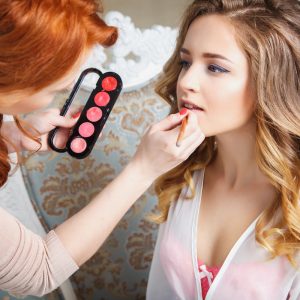 A woman getting her makeup done by a professional artist.