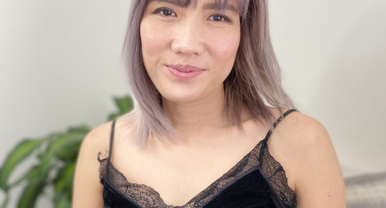 A woman with purple hair and black top.